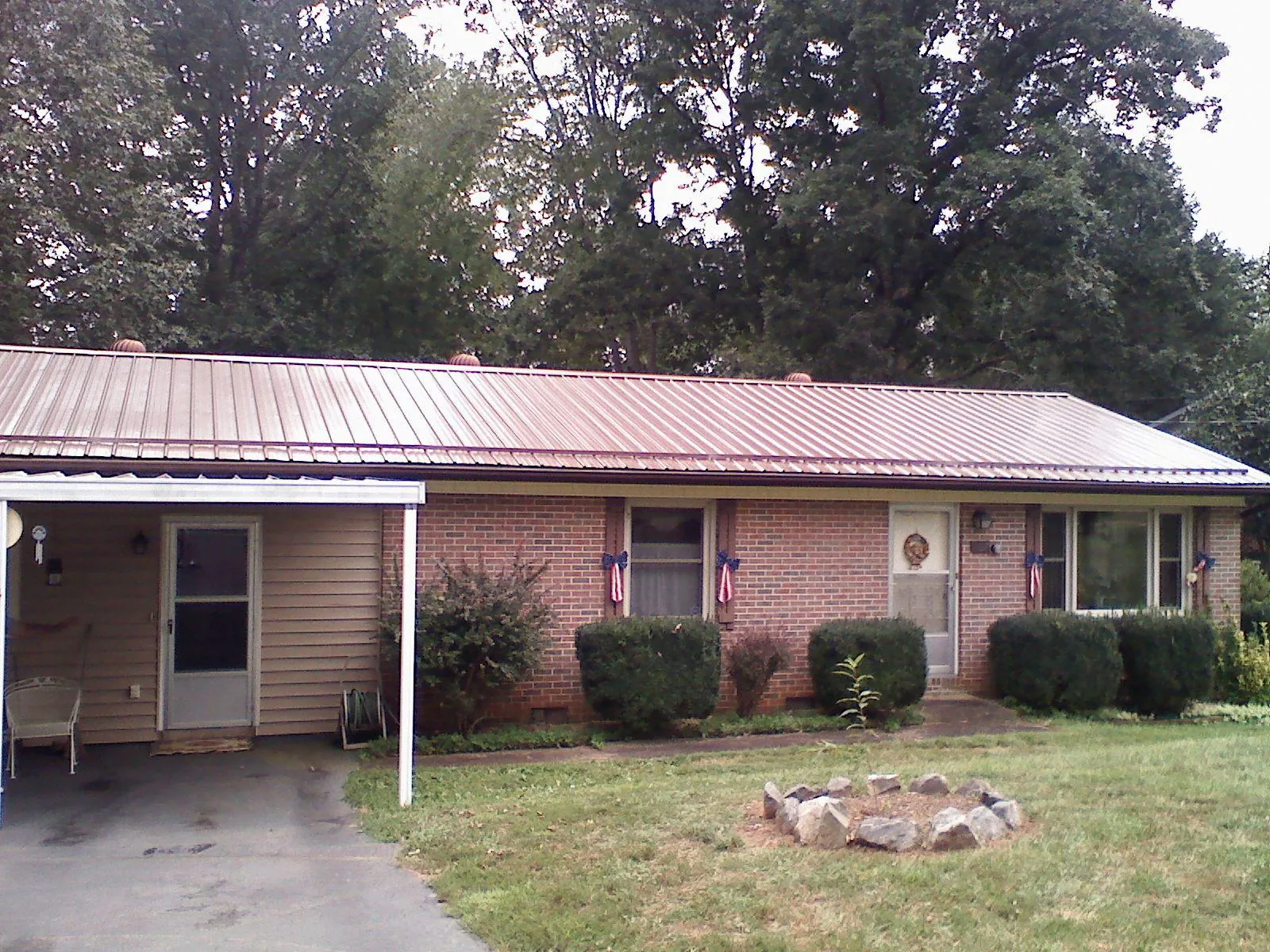 Bronze metal roof and carport on a brick ranch home — Roof Repair work by our crew in Belle Glade